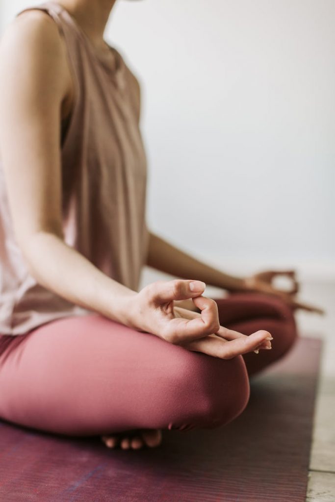 Close-up of a woman meditating in a serene indoor setting, focusing on wellness and relaxation.